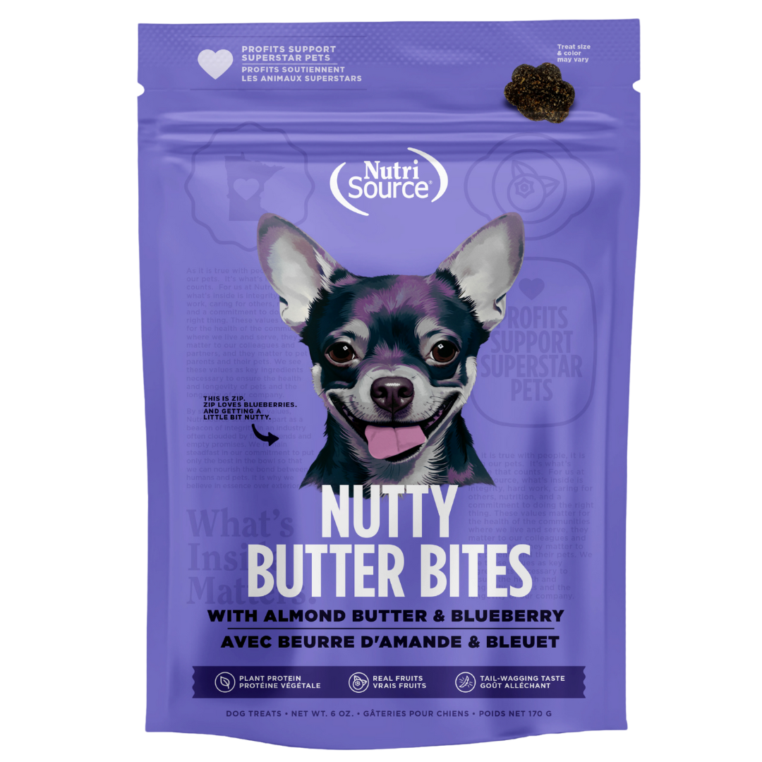 A package of NutriSource Almond Butter & Blueberry Nutty Butter Bites dog treats with an image of a happy dog on the front.