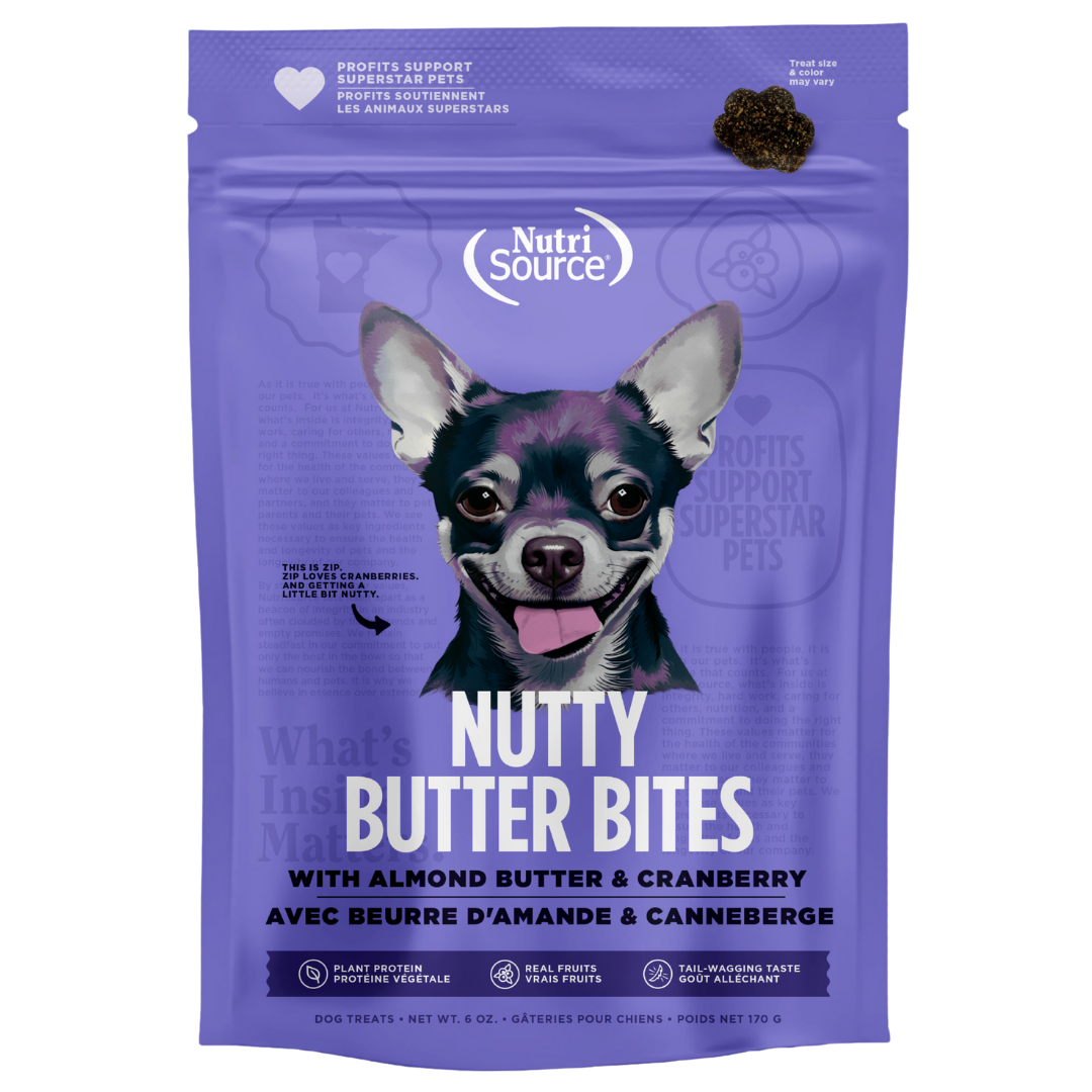 A package of NutriSource Almond Butter & Cranberry Nutty Butter Bites dog treats with an image of a happy dog on the front.