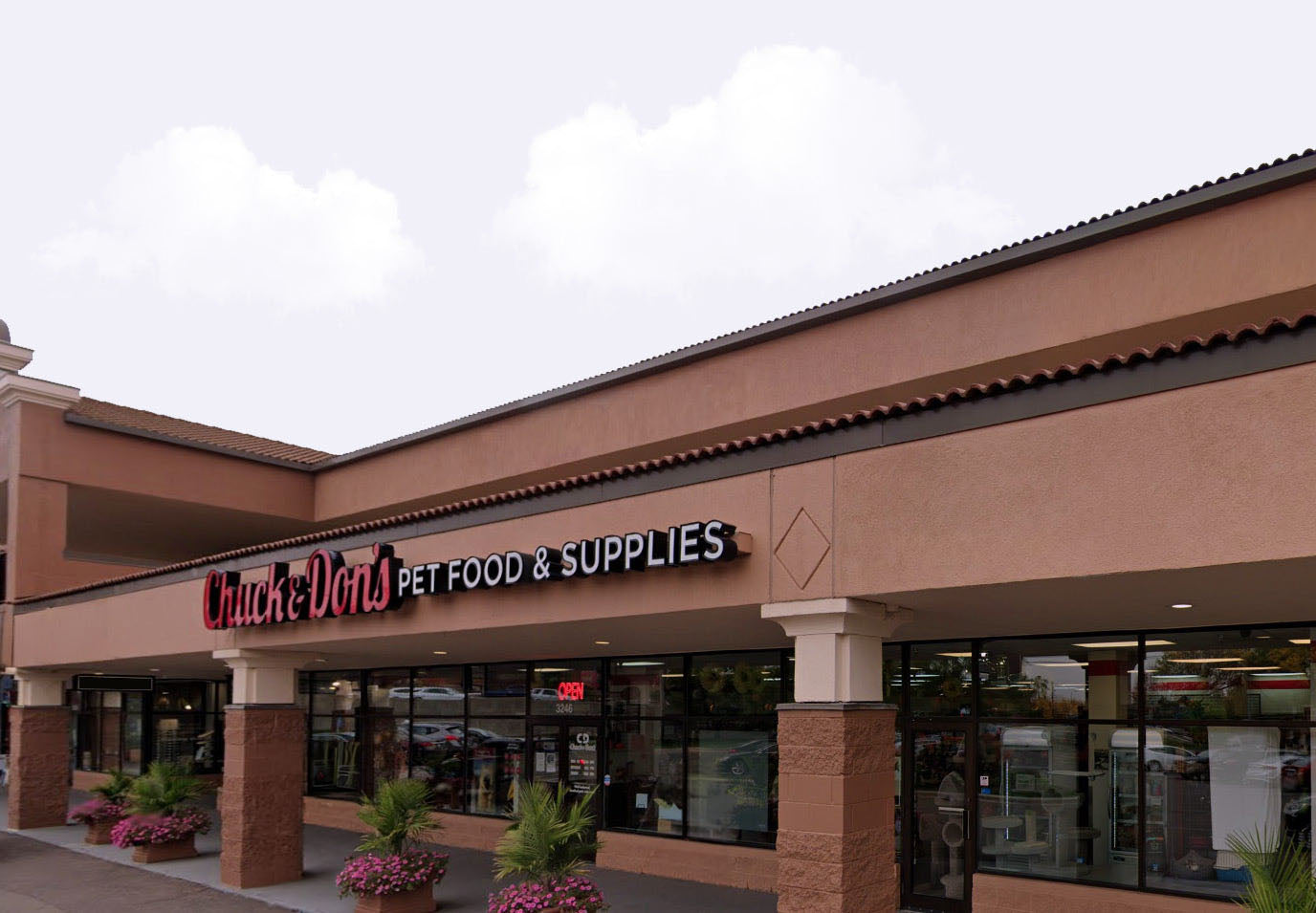 Chuck & Don's pet food and supplies store exterior with a cloudy sky