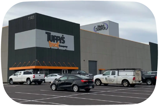 Commercial building with 'Tuffy's Trueat Company' branding and parked vehicles in front